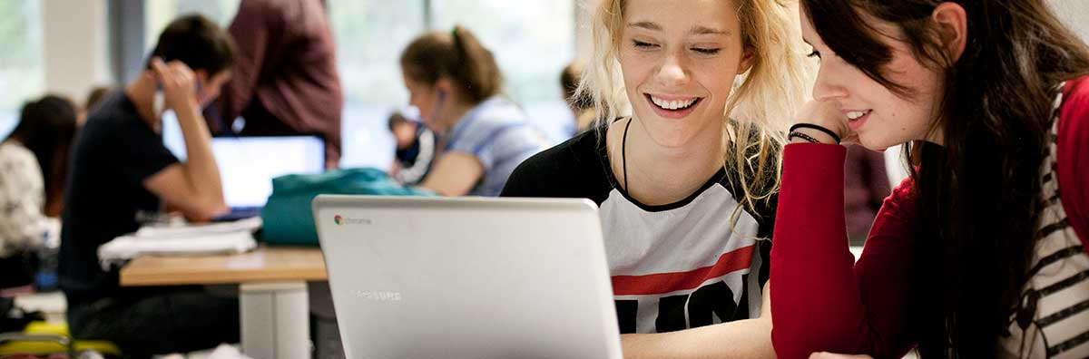 Communications & Marketing - Female students at laptop web 1200 x 396 - Maynooth University