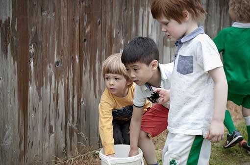 Creche - Children dipping in bucket - Maynooth University