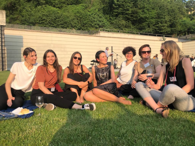 7 women sitting on the grass in the sun 