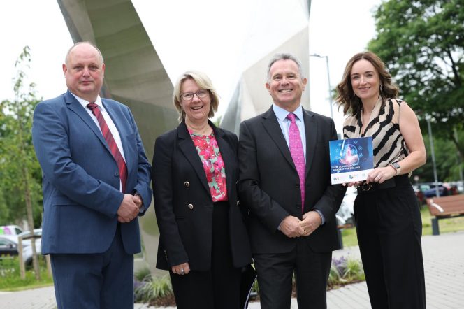 Man in blue suit, woman in black suit, man in dark suit and woman in striped top
