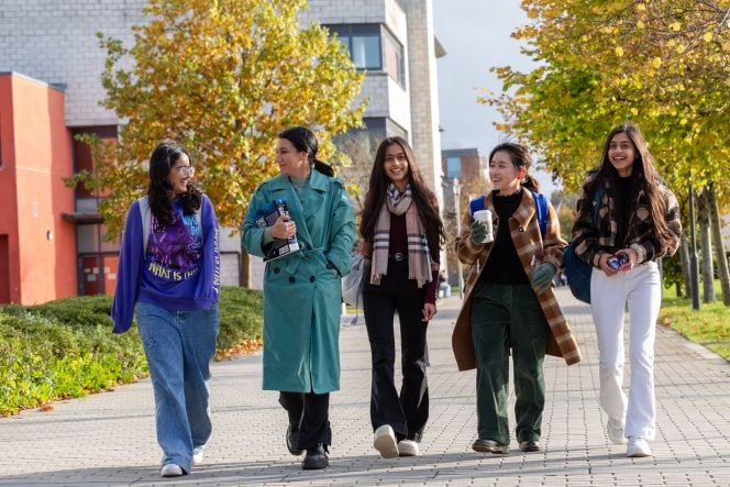 five female students walking together on a sunny day on maynooth campus