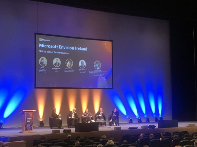 5 people sat on stage at the convention centre in Dublin with a large screen above them reading : Microsoft Envision Ireland Skill up Ireland Panel Discussion 