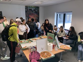 Students having pizza to celebrate launch