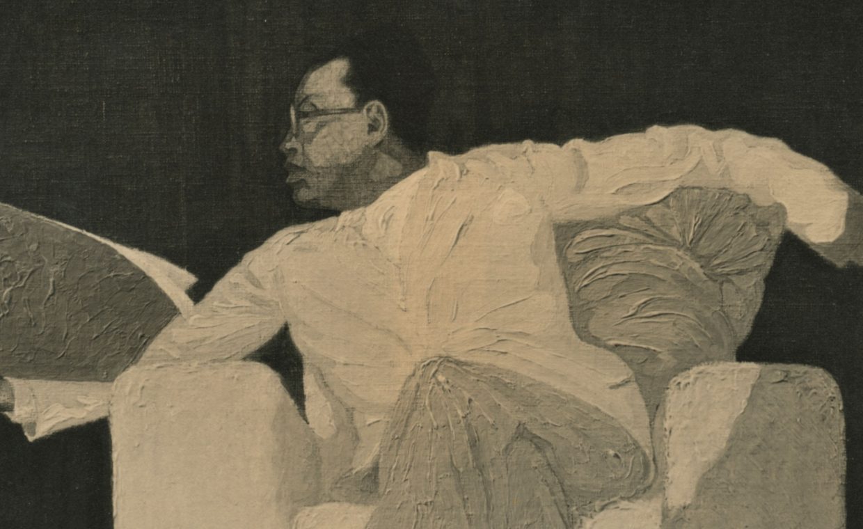 Black and white image of a man with glasses, in white clothes, sitting on an armchair