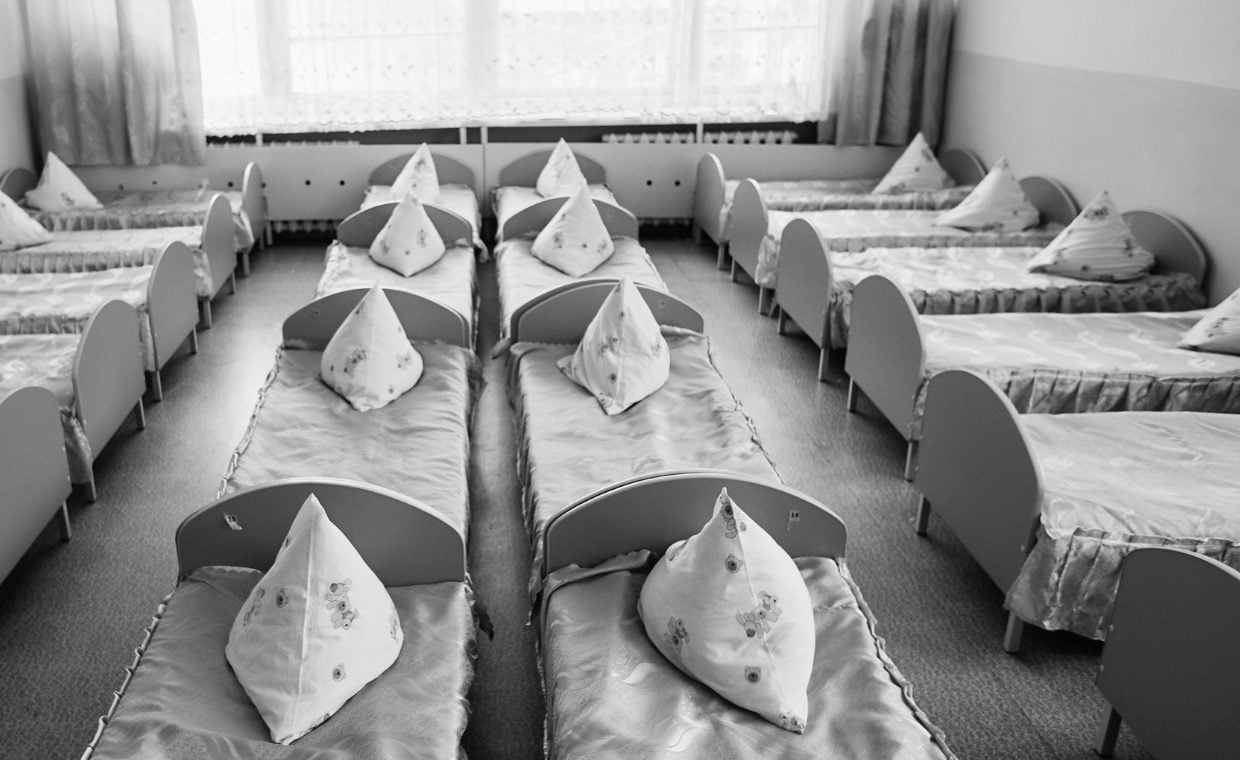 Rows of beds with grey covers and triangular pillows on top