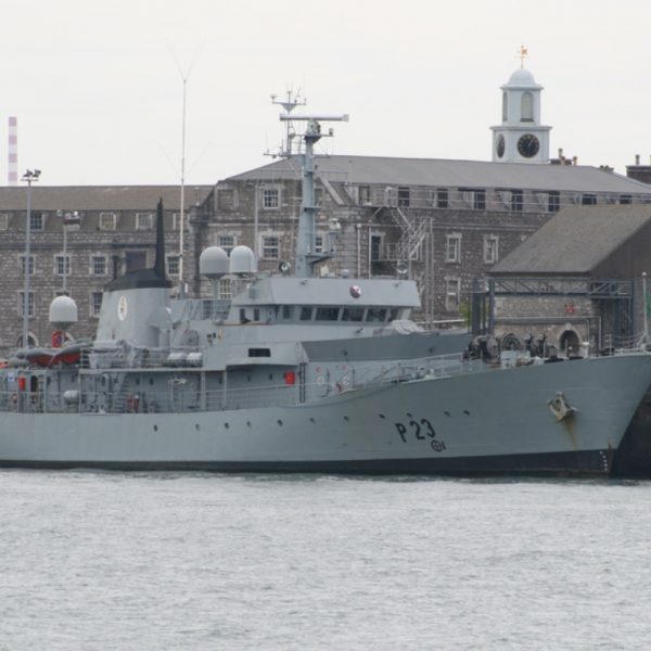 Irish naval vessel at dock in front of a large grey building