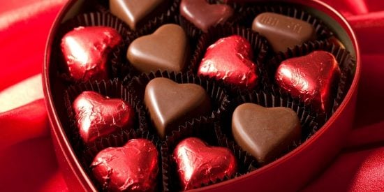 Red heart-shaped box of chocolates with heart-shaped chocolates in it