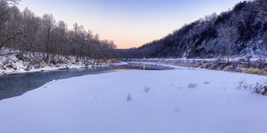 Picture of a river beside frozen ground