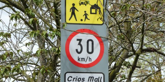 Road traffic signs showing children playing, speed limit of 30 km/h and saying Slow Zone