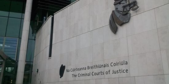 Sign reading The Criminal Courts of Justice with justice symbol