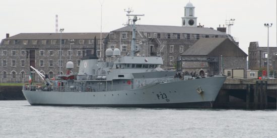 Irish naval vessel at dock in front of a large grey building