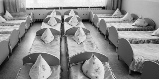 Rows of beds with grey covers and triangular pillows on top
