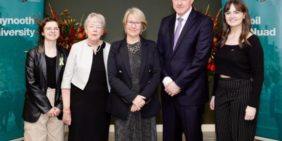 five people, 4 women and 1 man, smiling and looking into the camera