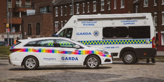 A garda car and van parked in front of some houses