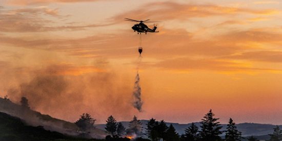 helicopter dropping water to fight a fire