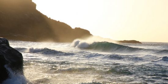 Waves with foam crashing again the coast