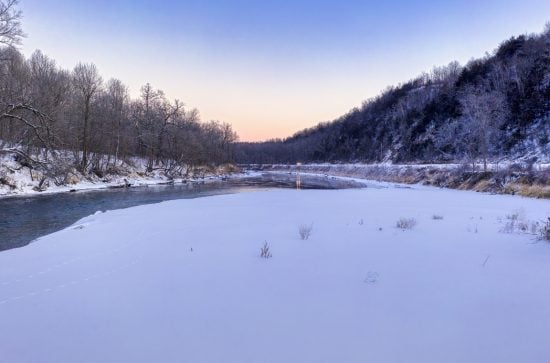 Picture of a river beside frozen ground