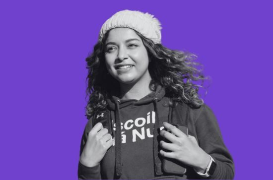 Student smiling, purple background.
